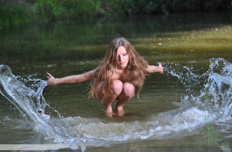 Naked model Conny piles up her hair while posing in the water 34943569