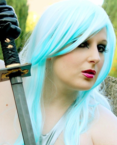 Fair skinned girl with dyed hair wields a sword while modelling latex clothing 68202153