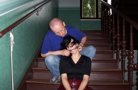 Brunette chick finds herself gagged and bound in leather pants on the stairs 11013072