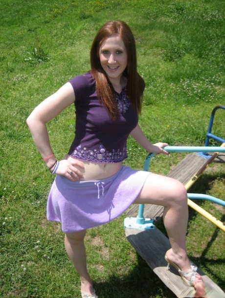 Young redhead flashes her breasts and panties while at a playground 96661361