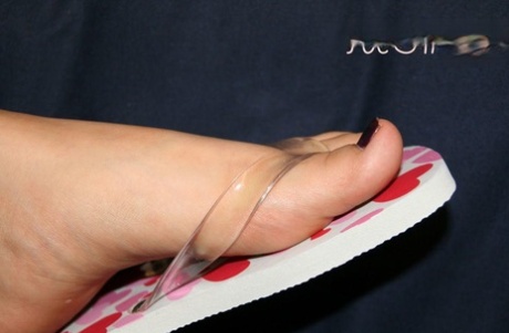 Caucasian female wiggles her pretty toes while wearing flip-flops 38803800