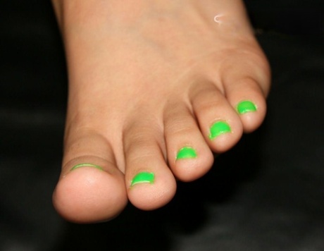 Caucasian female sports painted toenails while rubbing her bare feet together 58190505