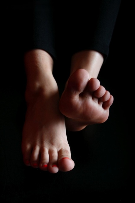Caucasian female rubs her pretty feet with her bare hands 70864943