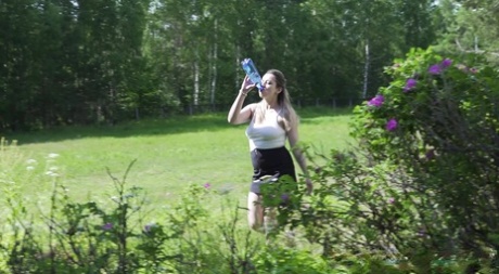 Caucasian girl Katya takes a piss over rubber tires behind a building 58158555